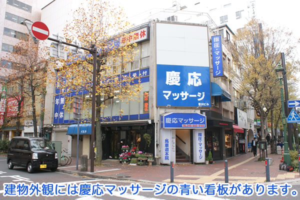 建物外観には慶応マッサージの青い看板があります。